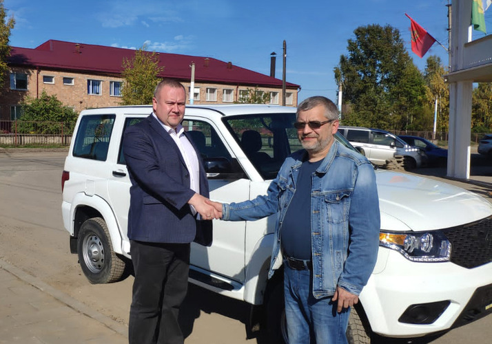 Алексей Медведев (слева) передал ключи от автомобиля представителю управления образования Администрации Богучанского района